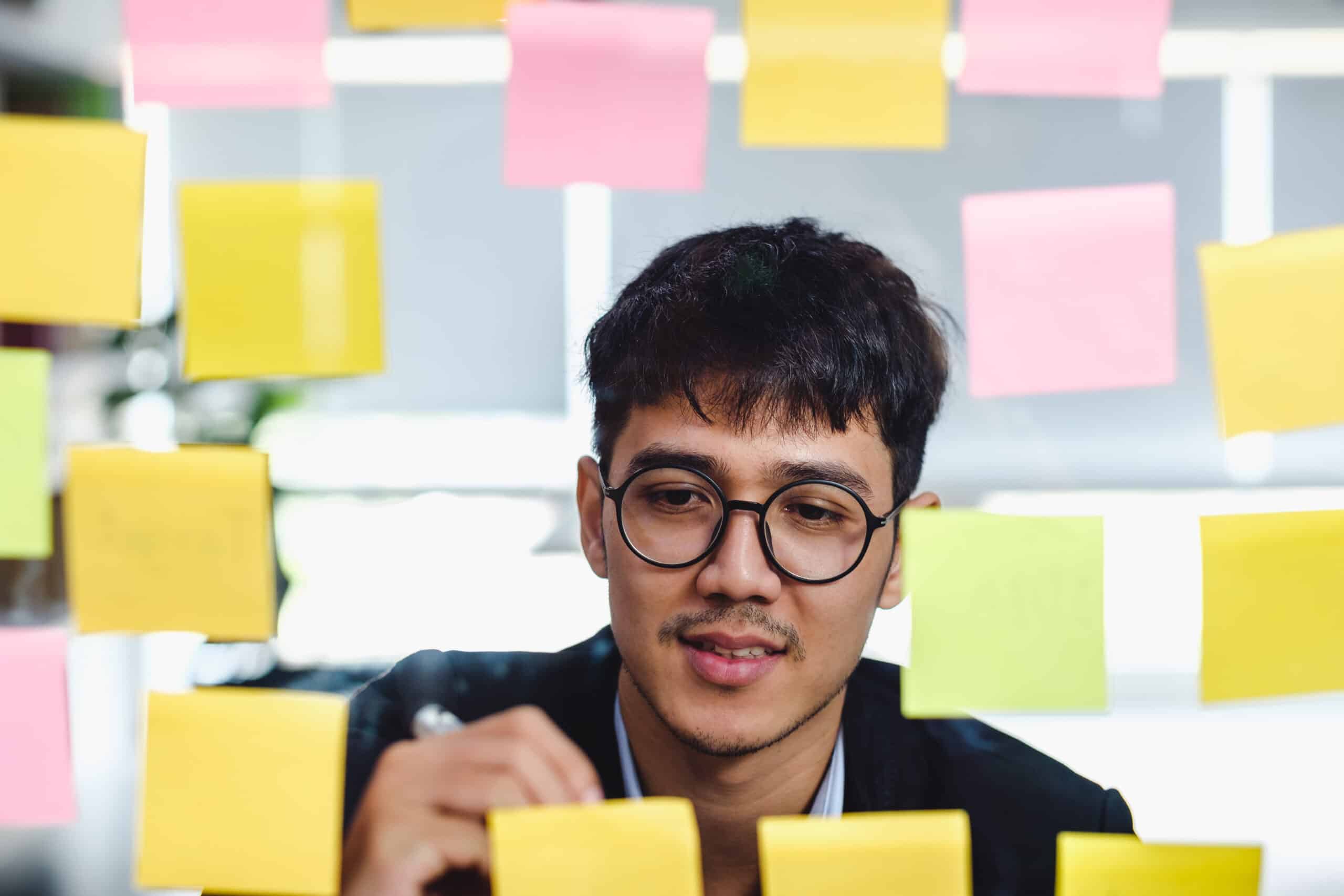 asian businessman looking and writing on sticky note for brainst