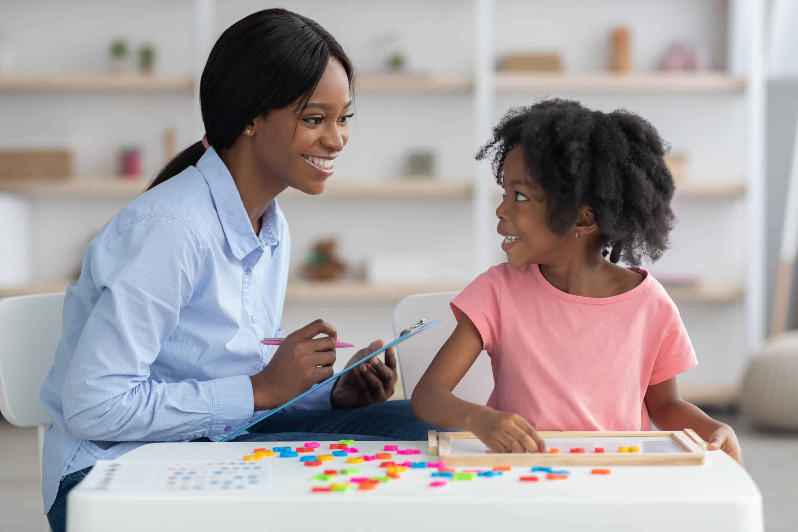 Cheerful child development specialist testing cute little girl