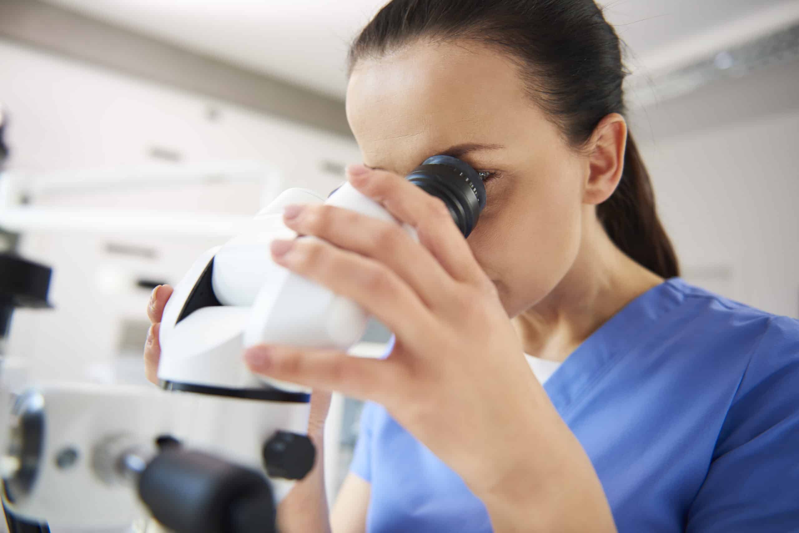 Close up of dentist looking through the dental microscope