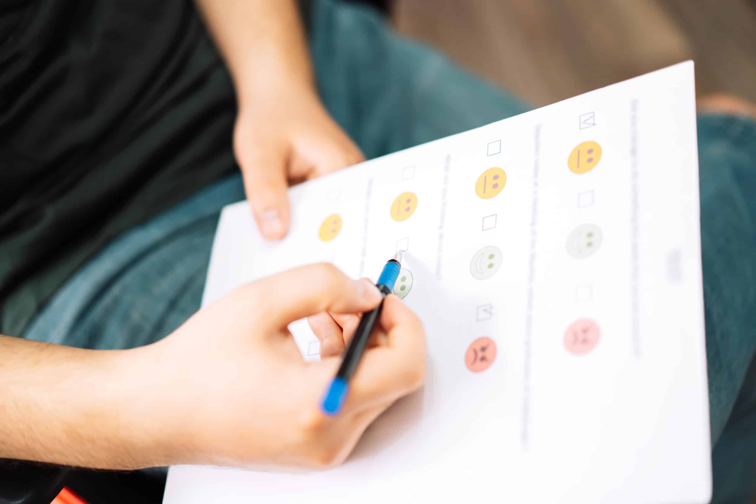 Man taking a psychological test with emoticons